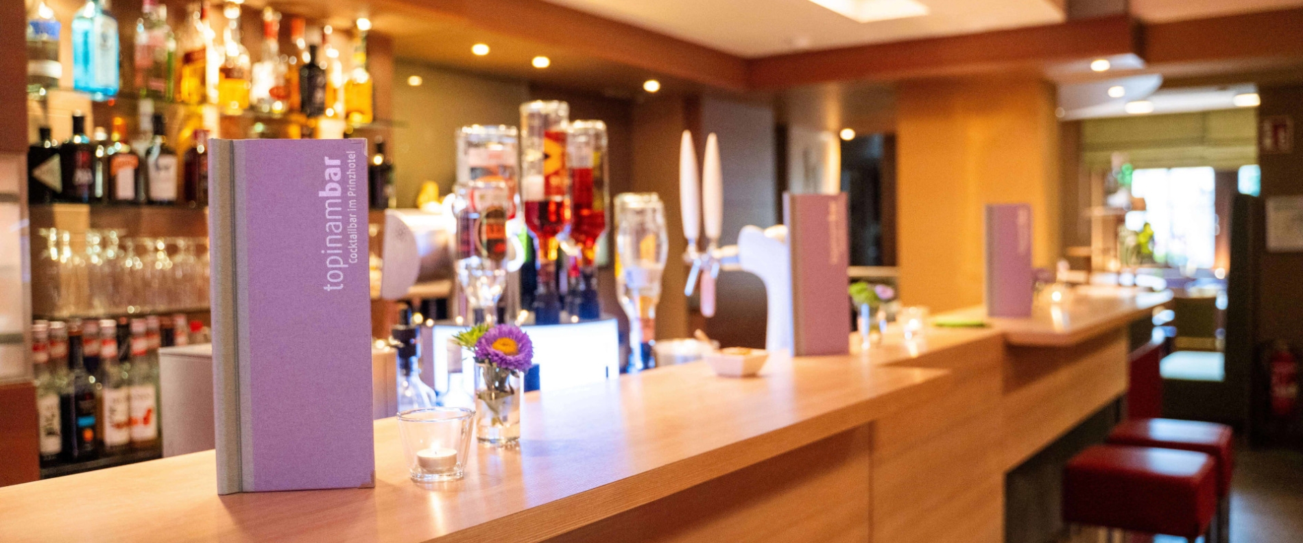 Moderne Bar-Theke mit Cocktailkarten und Barhockern in der Topinambar Cocktailbar Rothenburg