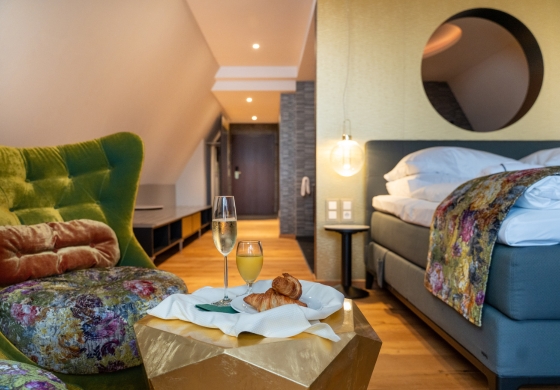 Aqua Spa Suite im Prinzhotel Rothenburg – modernes Doppelbett mit Sitzbereich und Frühstück auf dem Tisch