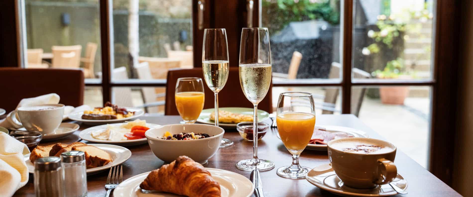 Frühstück im Prinzhotel Rothenburg – gedeckter Tisch mit Säften, Kaffee und Gebäck mit Blick auf die Terrasse