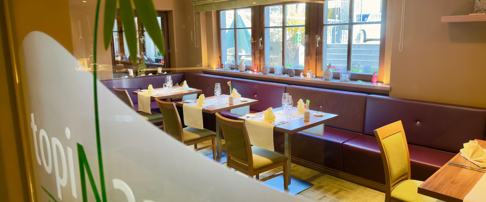 Restaurant Topinambur im Hotel in Rothenburg ob der Tauber mit gedeckten Tischen und Sitzb&auml;nken am Fenster